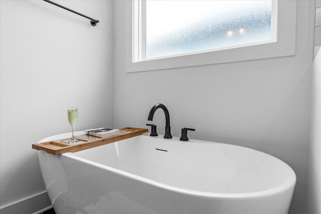 bathroom featuring a sink and a freestanding bath