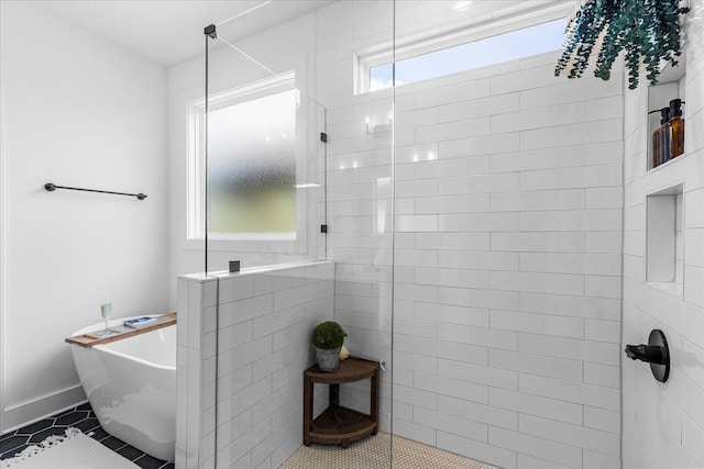 full bathroom featuring tile patterned floors, baseboards, a soaking tub, and walk in shower