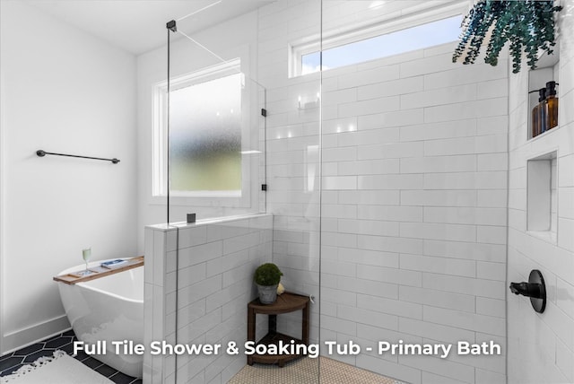 bathroom featuring baseboards, a freestanding bath, walk in shower, and tile patterned flooring