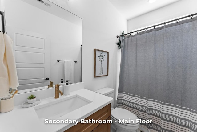 full bath with visible vents, toilet, vanity, and a shower with curtain