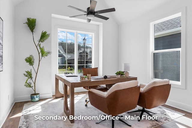 home office featuring vaulted ceiling, ceiling fan, baseboards, and wood finished floors