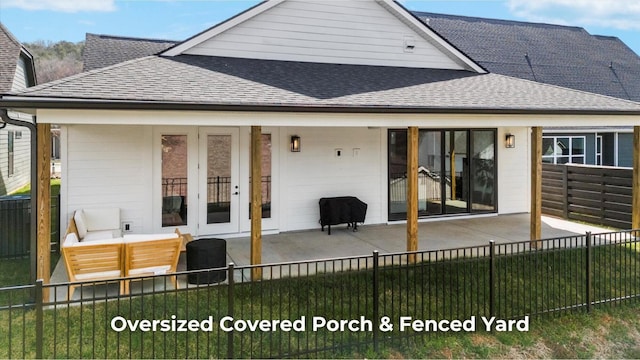 back of property featuring roof with shingles, a fenced backyard, and a patio area