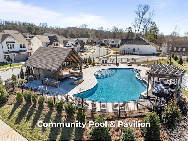 community pool with a patio area, a residential view, outdoor dry bar, and fence