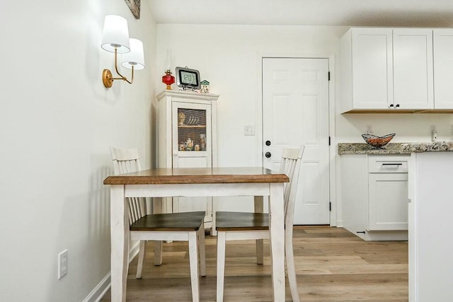 unfurnished dining area featuring light wood-style floors and baseboards