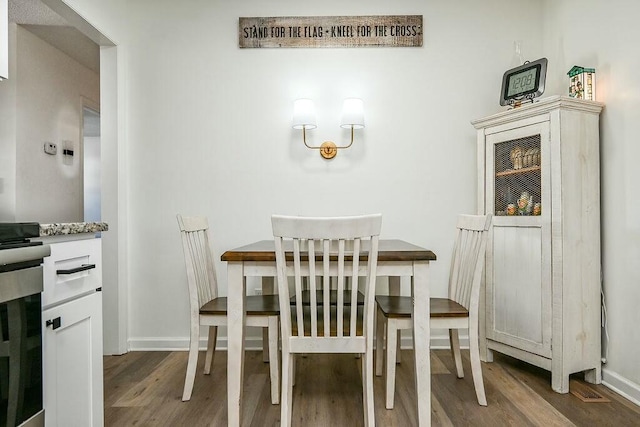 dining area featuring baseboards and wood finished floors