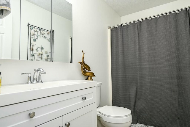 full bathroom featuring toilet, a shower with shower curtain, a textured ceiling, and vanity