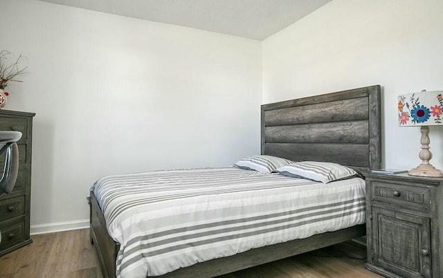 bedroom with baseboards and wood finished floors