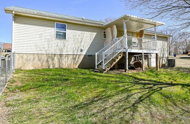 back of property featuring a yard, crawl space, fence, metal roof, and stairs