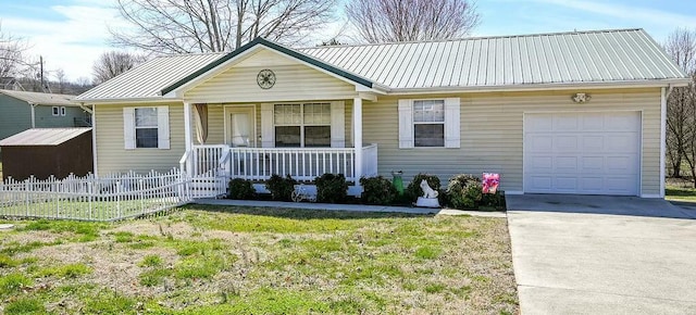 view of front of house featuring covered porch, concrete driveway, fence, metal roof, and a garage