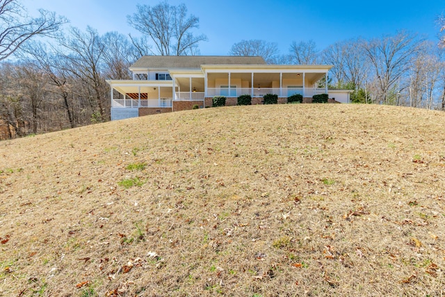 ranch-style house featuring covered porch and a front yard