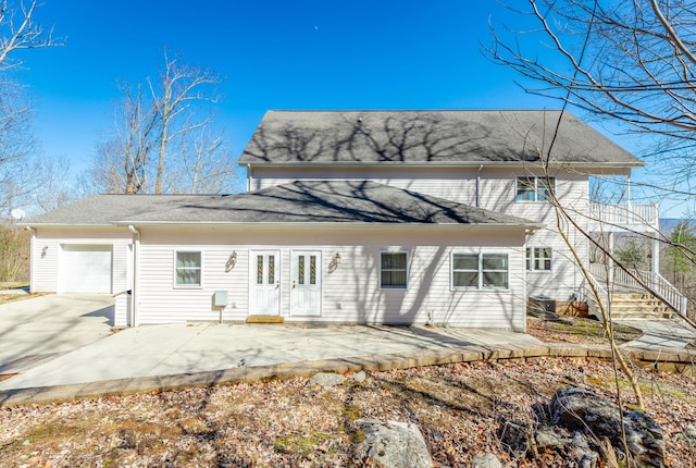 back of property with a patio area, driveway, and an attached garage