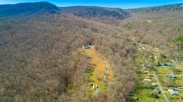 birds eye view of property with a mountain view and a wooded view