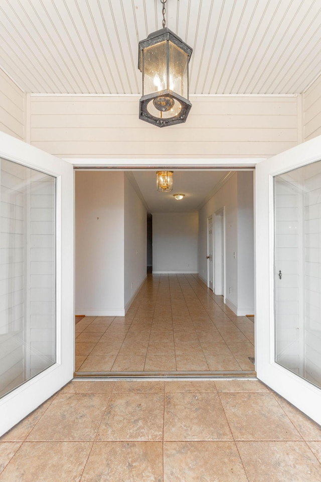 hall with a chandelier and tile patterned flooring