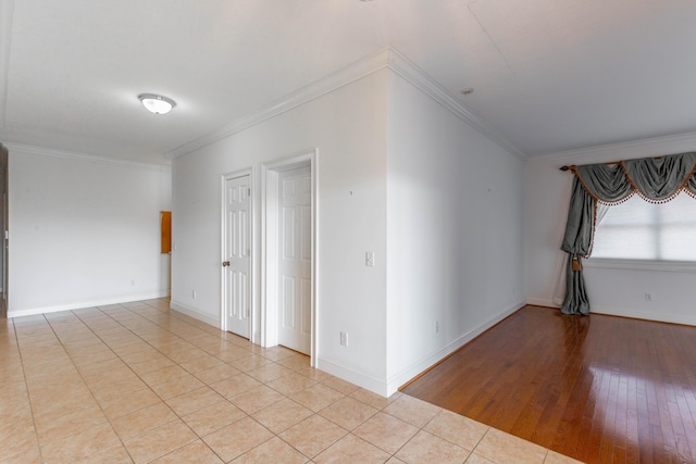 tiled empty room with crown molding and baseboards