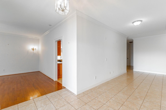 unfurnished room featuring light tile patterned floors, crown molding, baseboards, and a notable chandelier