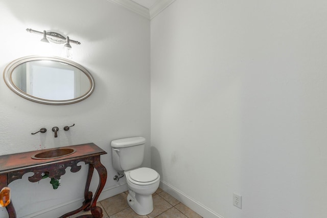 bathroom featuring ornamental molding, tile patterned flooring, toilet, and baseboards