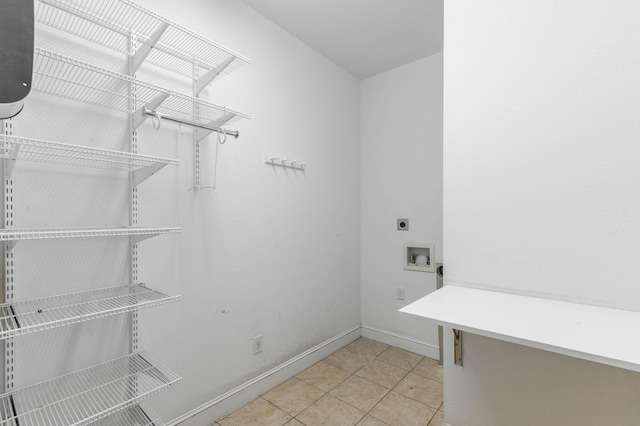 laundry room with laundry area, baseboards, tile patterned floors, hookup for a washing machine, and hookup for an electric dryer