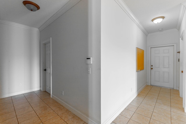 corridor with ornamental molding, baseboards, and light tile patterned floors