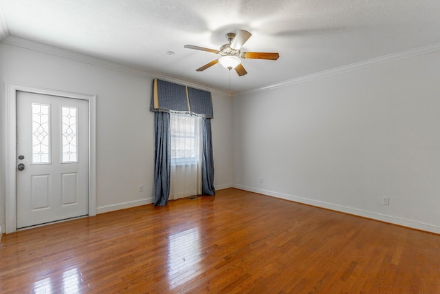 entrance foyer with ornamental molding, baseboards, hardwood / wood-style floors, and a ceiling fan