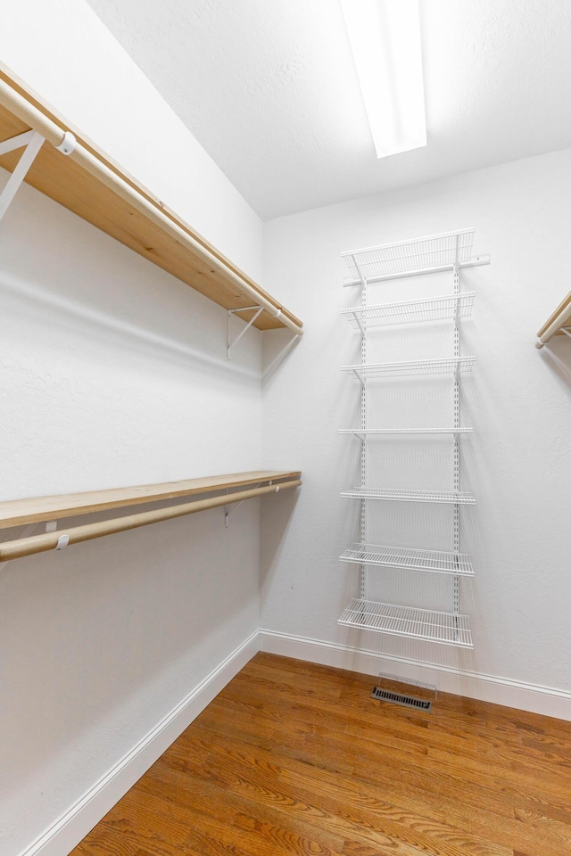 walk in closet with wood finished floors and visible vents