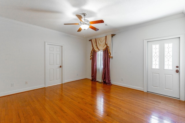 spare room featuring light wood-style floors, baseboards, and crown molding