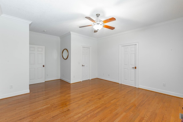 spare room with light wood finished floors, ceiling fan, ornamental molding, and baseboards