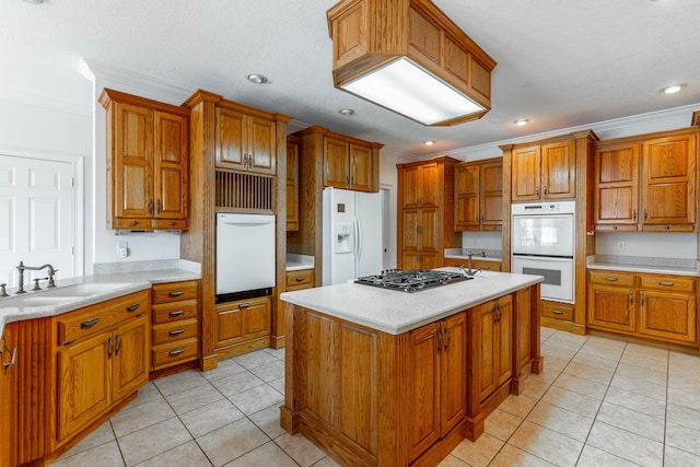 kitchen featuring light tile patterned floors, white appliances, a kitchen island, a sink, and brown cabinetry