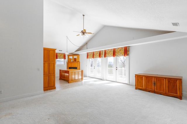 unfurnished living room with ceiling fan, high vaulted ceiling, light carpet, visible vents, and french doors