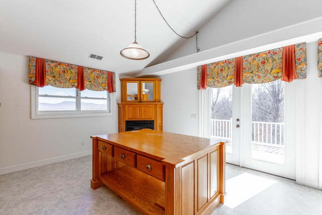 kitchen with vaulted ceiling, wooden counters, a fireplace, and a healthy amount of sunlight