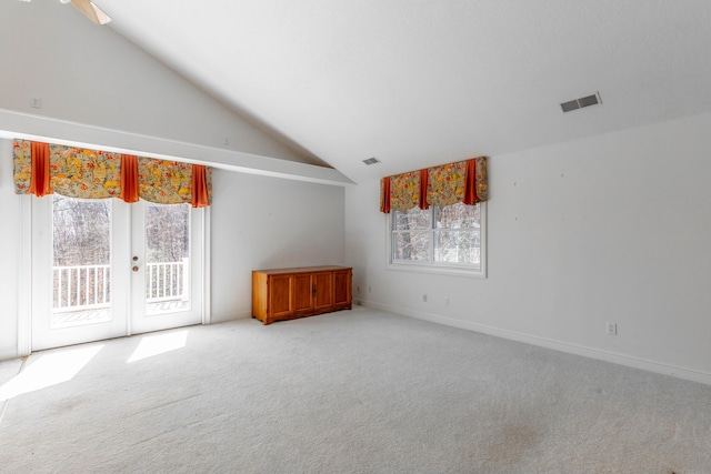 carpeted empty room with a wealth of natural light, french doors, and visible vents