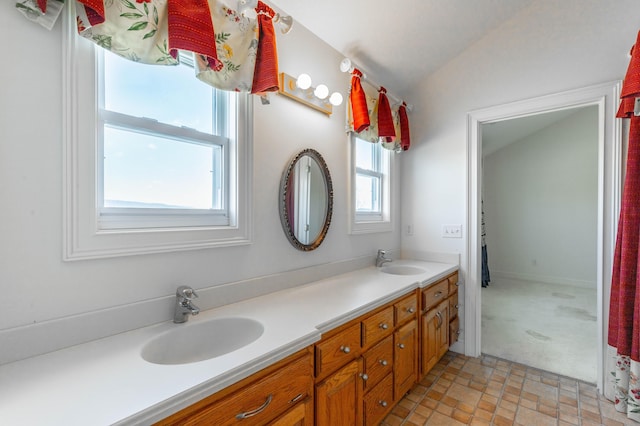 full bathroom featuring double vanity, vaulted ceiling, and a sink