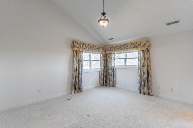 carpeted spare room with vaulted ceiling, visible vents, and baseboards