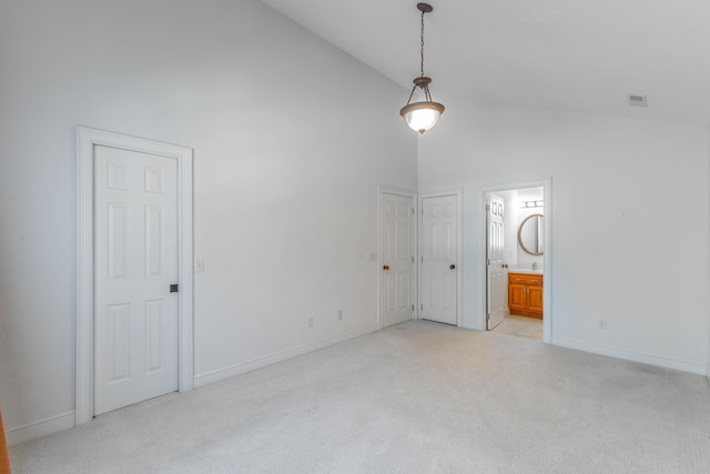 interior space with light carpet, high vaulted ceiling, and baseboards