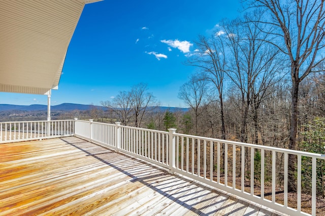 deck featuring a mountain view and a wooded view