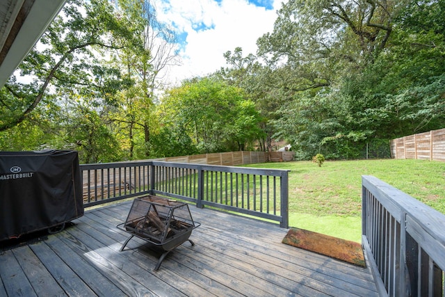 wooden terrace with a yard, a grill, a fenced backyard, and an outdoor fire pit