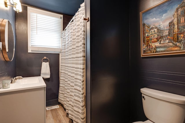 full bathroom featuring vanity, curtained shower, toilet, and wood finished floors