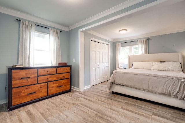 bedroom featuring light wood-type flooring, baseboards, a closet, and crown molding