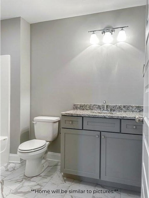 full bath featuring a bathing tub, toilet, vanity, baseboards, and marble finish floor