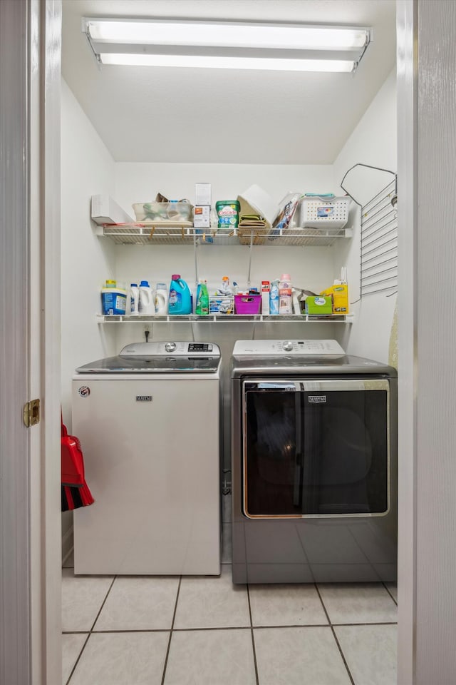 laundry area with laundry area, light tile patterned flooring, and independent washer and dryer