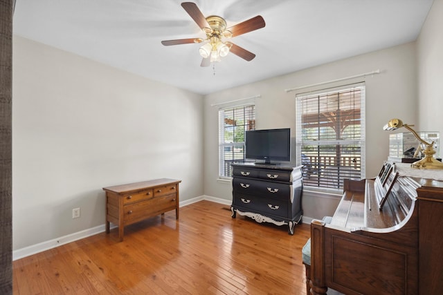 bedroom featuring a ceiling fan, baseboards, and light wood finished floors