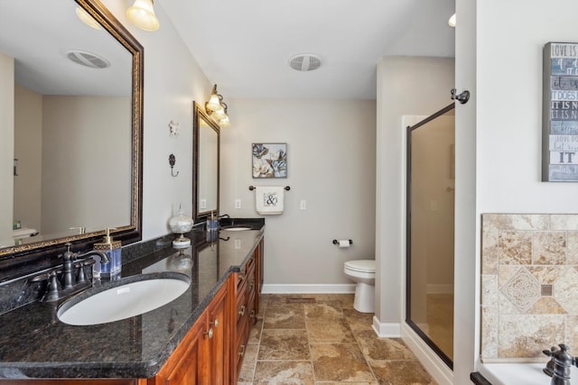 bathroom with double vanity, a sink, toilet, and a shower stall