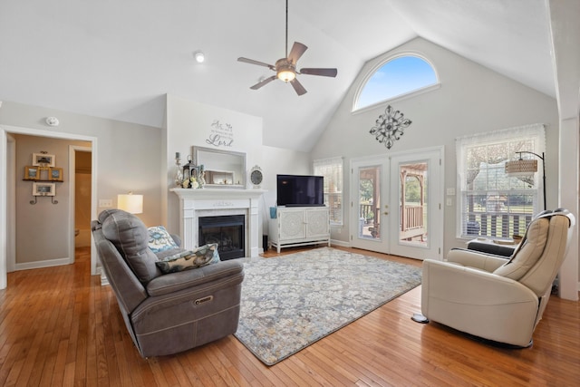 living room featuring french doors, a fireplace, ceiling fan, high vaulted ceiling, and hardwood / wood-style flooring