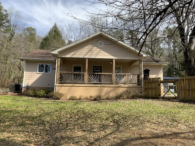 view of front of property with covered porch, a front yard, fence, and a gate