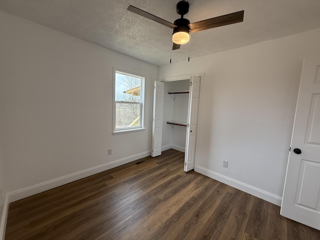 unfurnished bedroom with visible vents, baseboards, ceiling fan, dark wood-type flooring, and a textured ceiling