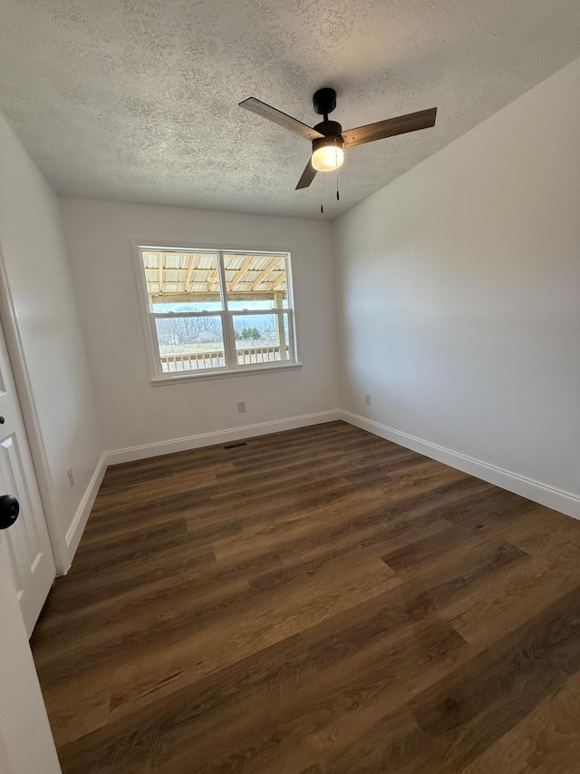 unfurnished room with dark wood-style floors, visible vents, a ceiling fan, a textured ceiling, and baseboards