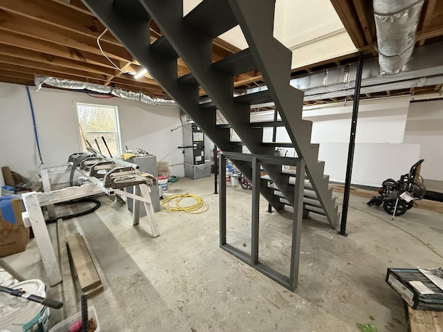 basement featuring heating unit and stairs