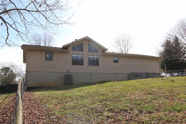 view of property exterior with a yard, central AC unit, and fence