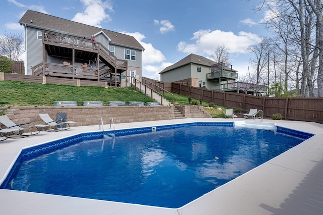 view of swimming pool with fence, a fenced in pool, a wooden deck, stairs, and a patio area