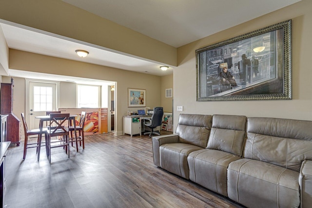 living area with visible vents and wood finished floors