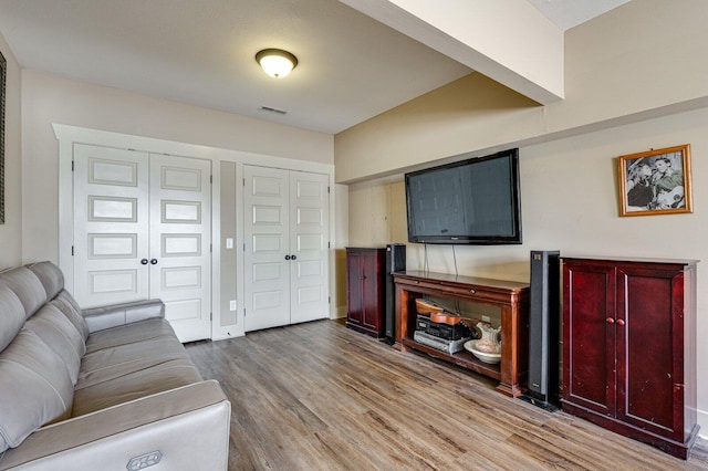 living room featuring wood finished floors, visible vents, and baseboards